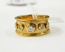 Gold coloured metal and diamond dress ring, having 7 collet set diamonds, raised edges,