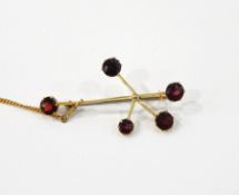 Gold-coloured metal and garnet abstract brooch