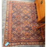 A Persian medallion design rug in blue and red, with cream border,