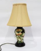 Moorcroft vase turned into a table lamp with cream shade, on a wooden plinth base,