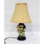Moorcroft vase turned into a table lamp with cream shade, on a wooden plinth base,