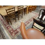 Persian-style wool carpet, the cream ground allover floral decorated with red ground herati border,
