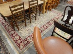 Persian-style wool carpet, the cream ground allover floral decorated with red ground herati border,