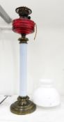 Cranberry, white opaline and brass oil lamp, the cranberry cut well with faceted sides,