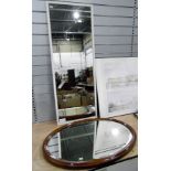 An oval bevelled oak framed mirror, 82 cms, with a wall hanging mirror,