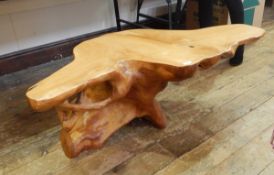 Modern coffee table made from a shaped tree trunk, with carved detail,