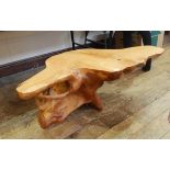 Modern coffee table made from a shaped tree trunk, with carved detail,