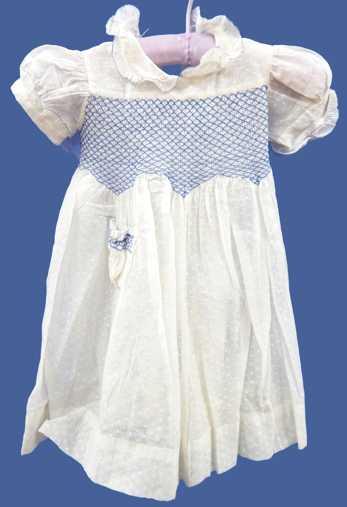 Various 1940's or earlier child's dresses including a cream figured muslin with blue smocking
