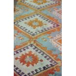 Turkish wool rug, green ground with diamond central design, cream, yellow and orange borders,