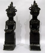Pair of African metal seated figures holding bowls,