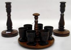 Pair of turned wood baluster-shaped candlesticks and matching set of six egg cups on stand