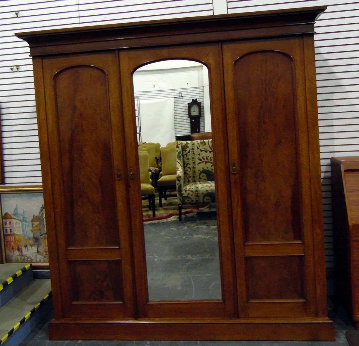 Victorian mahogany triple wardrobe with arched flame mahogany cross-banded panelled doors,