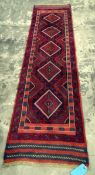 Meshwani wool runner with five lozenge-shaped medallions to the cherry red ground and having