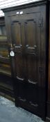 Oak hall robe enclosed by a six-panelled geometric patterned door, with iron H-hinges,
