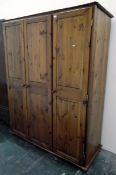 20th century modern stained pine wardrobe comprising of three panelled doors enclosing hanging