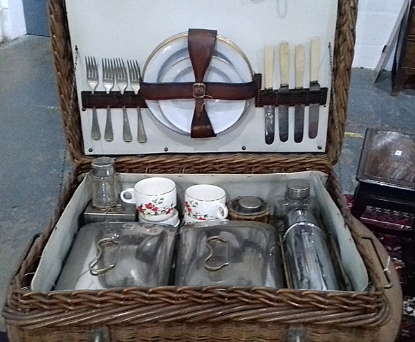 Vintage wicker picnic hamper with silver plated flatware, china cups and plates,