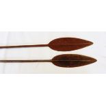 Pair of African wood and metal long-handled spears with pointed ends,