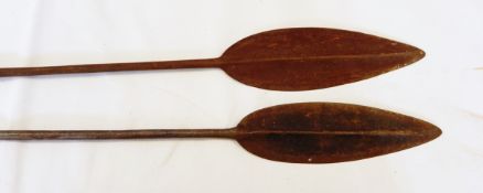 Pair of African wood and metal long-handled spears with pointed ends,