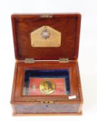 Walnut veneered box with glazed interior enclosing Boer War Queen Victoria chocolate tin (no