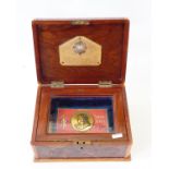 Walnut veneered box with glazed interior enclosing Boer War Queen Victoria chocolate tin (no