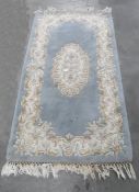 Chinese wool rug with pink, blue and ivory flowers, on a pale blue ground, 147cm x 78cm and another,