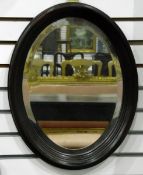 Oval wall mirror with bevelled plate, within a mahogany moulded frame,