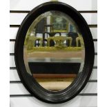 Oval wall mirror with bevelled plate, within a mahogany moulded frame,