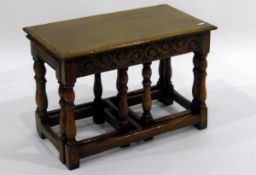 Nest of three oak occasional tables with carved frieze, on turned baluster legs,