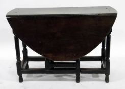 Georgian oak oval-top gateleg table, on turned legs united by stretchers,