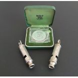 Two vintage Police whistles and a silver proof crown coin,