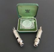 Two vintage Police whistles and a silver proof crown coin,