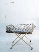 White painted cast metal and net crib on X-frame supports,
