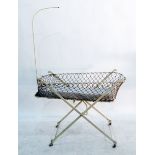 White painted cast metal and net crib on X-frame supports,