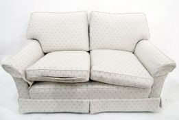 Modern beige upholstered two-seater sofa