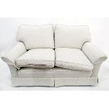 Modern beige upholstered two-seater sofa