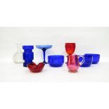 Three blue glass finger bowls, a cranberry glass jug, a red pressed glass goblet,