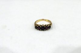 9ct gold garnet set ring with five graduated oval stones, 4g in total,