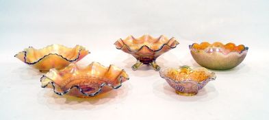 Five marigold Carnival glass bowls including one decorated with cherries on a tripod base,