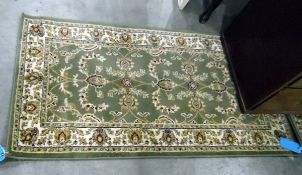 Pair of Eastern style rugs, green ground with floral decoration,