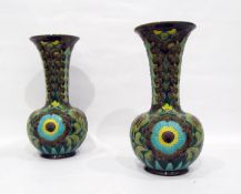 Pair of Burmantoft Faience vases of bottle form with flared rims, decorated with flowers, in yellow,