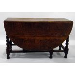 Oak gateleg dining table with richly veined top, rounded flaps, two frieze drawers,