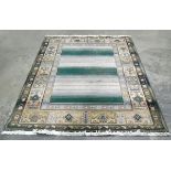 Large Oriental style rug, fringed, central panel in pale green and cream, with decorated border,