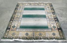 Large Oriental style rug, fringed, central panel in pale green and cream, with decorated border,