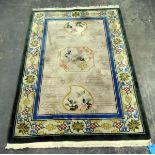 Washed Chinese style rug depicting exotic birds and with a floral border, fringed,