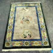 Washed Chinese style rug depicting exotic birds and with a floral border, fringed,