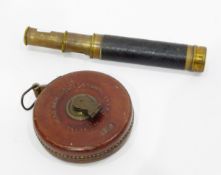 Three-draw brass telescope with leather sleeve, a 50ft tape measure in leather case,