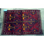 Old Baluchi wool rug with four stylised orange tulips to the red field and having stiff leaf