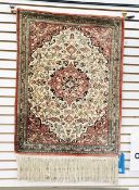 Silk prayer rug showing animals, with a central cartouche, all on a pale rust-coloured ground,
