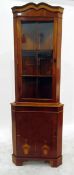 Reproduction walnut corner cabinet with glazed upper section enclosing two shelves,