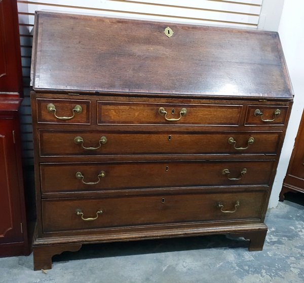 Georgian oak gentleman's bureau, the fall-front enclosing a fitted interior of central cupboard,